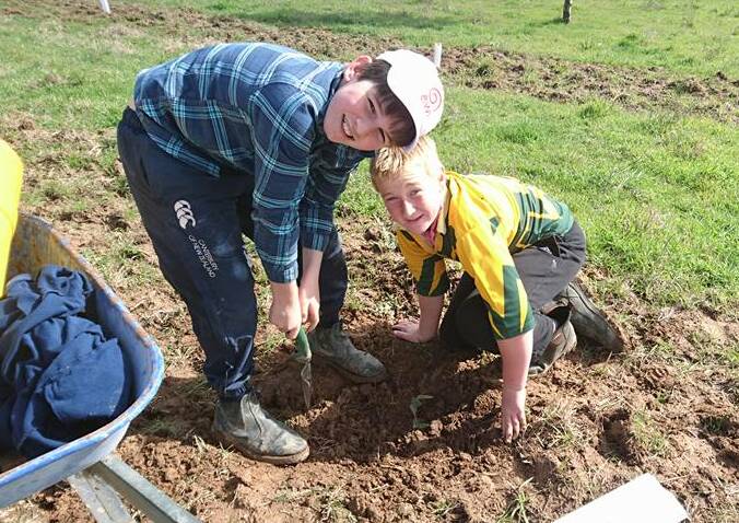 Fergus Mullen and Cooper get the soil ready for tree planting. Students from PLC in Sydney will learn all about the region from St Joseph's students in September. 