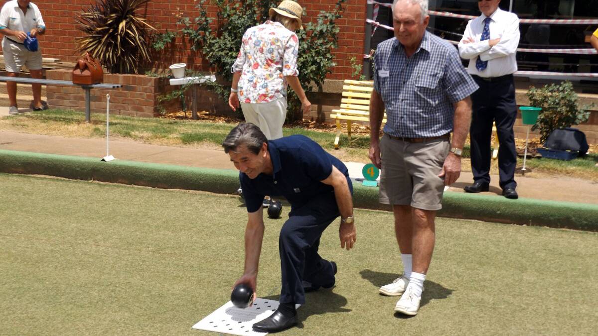 AMBASSADOR BOWLS: Ambassador John Paul Young lets a bowl go to start the Australia Day Bowls at the Boorowa Ex Services Club watched by John Crowe and Australia Day Committee President John Snelling.