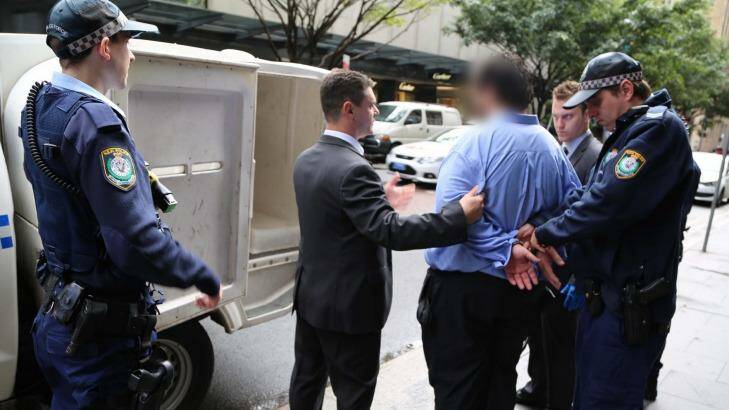 Police lead the 34-year-old lawyer from his Martin Place office. Photo: Supplied
