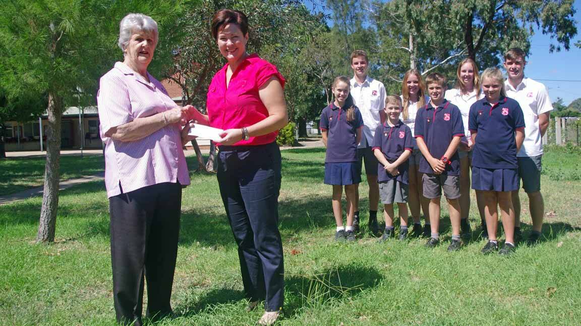Boorowa Courthouse Arts and Crafts president Dawn Barton presents Boorowa Central School principal Jennifer Green with a cheque for $1000. Front row: Boorowa Central junior captains Marlie McIntosh, Joshua Gurney, Jacob Piper and Grace Barker. Back row: Boorowa Central senior captains Alex Blomfield, Hayley Saunders, Payten Power and Michael Hinds.
