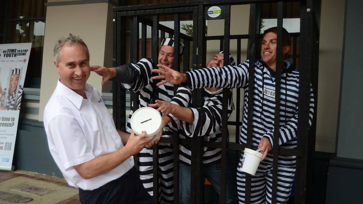 YOUNG: Representatives from 10 of Young’s businesses got a taste of life behind bars outside the town hall on Thursday. Steve Elsley of South West Slopes Credit Union, Wes Heather of Roccy FM and local builder Adam Tanner all grab for PCYC manager Martin Langfield.