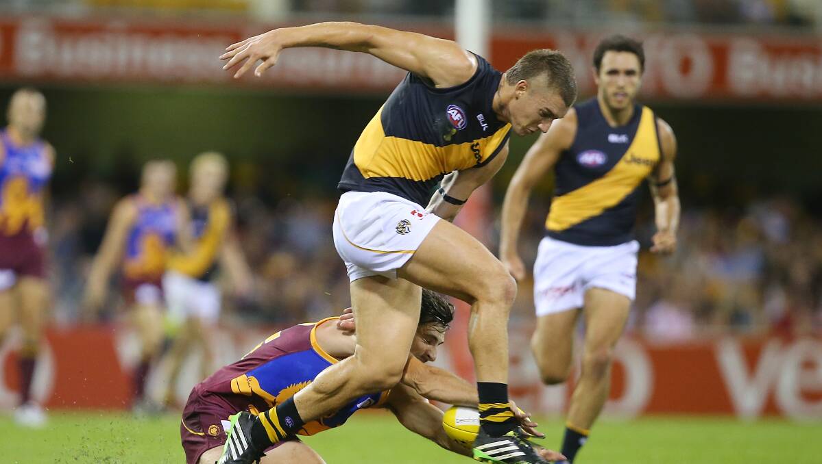 Dustin Martin of the Tigers kicks during the round five AFL match between the Brisbane Lions and the Richmond Tigers at The Gabba on April 17, 2014 in Brisbane, Australia. Photo: Chris Hyde/Getty Images.