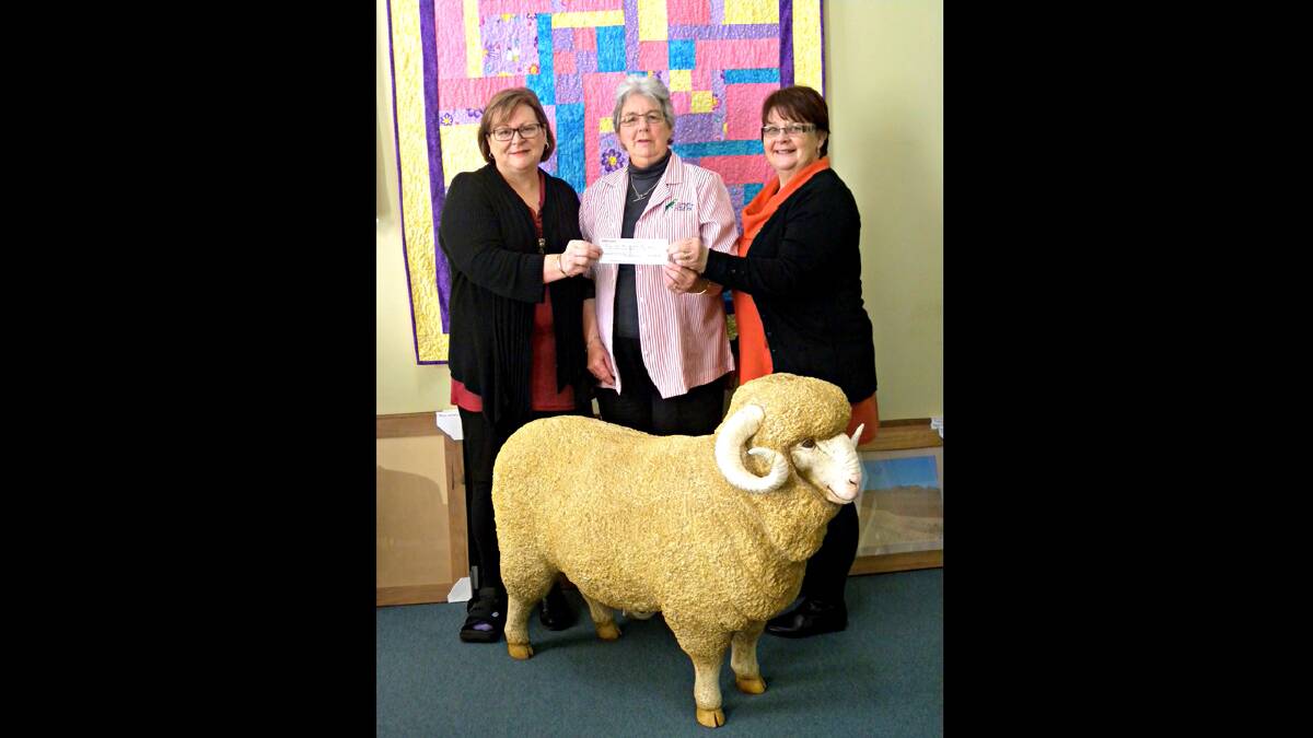 Leanne Croker (left) and Judy Ford (right, representing the Boorowa Wool Harvesting Association, receive a donation of $3000 from Boorowa Court House Arts and Crafts Secretary, Lorne Spackman. Many members of the Craft Shop have a rural background and appreciate the opportunity to support and encourage the work of the association.