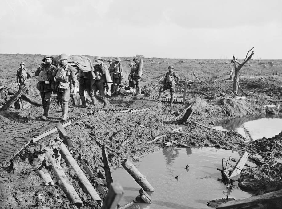 DEVASTATION: An Australian stretcher party brings in wounded soldiers along a duckboard track near Garter Point in the Ypres sector on October 15, 1917. Photo: AWM E01127 