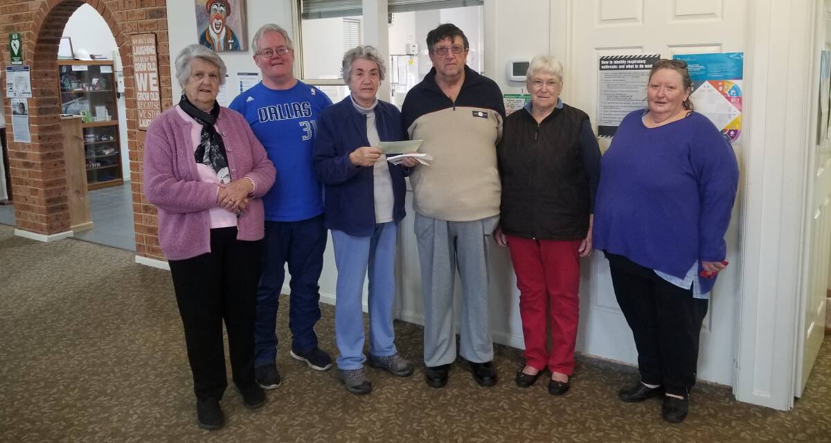 Maureen Beer (third from left) presenting the President of Burrowa House, Ian Randolph (centre) with the funds raised from the afternoon. 