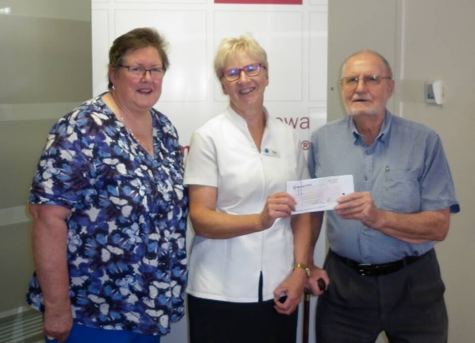 Sue Corcoran of the Boorowa Community Bank presents Derrick Mason and Cathy Walsh with a cheque for $11,000 as the Community Enterprise Foundations contribution to restoration of stained-glass windows at St Johns Church. The work on the windows began this week.