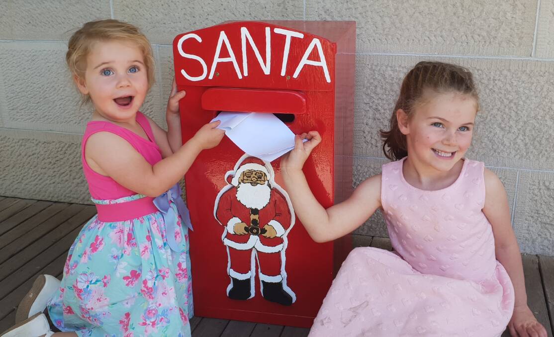 Sophee and Maya Hewitt putting their letters to Santa in the box. 