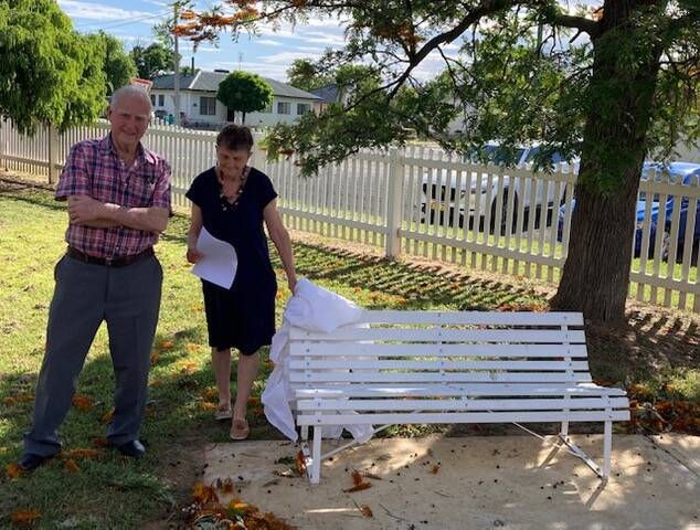 Bronwyn Fickle unveils the new seat at the Boorowa Uniting Church, which was donated by the M&D Society. Standing by is Bede Morrissey, who provided and assembled the new amenity.