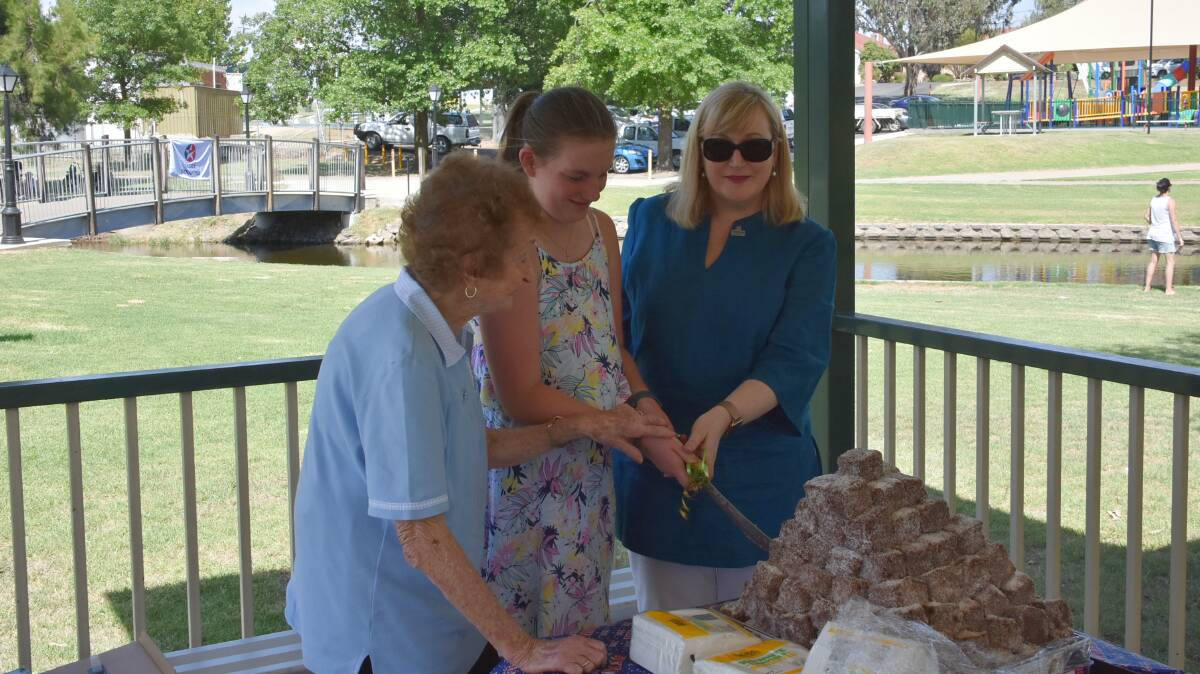 Yvonne Malone, Majella McGrath and Donna Ciccia cut the traditional Australia Day cake made out of lamingtons. Photo: Ben Rodin