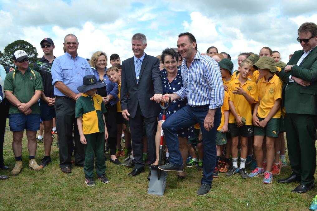 Hilltops Council Mayor Brian Ingram, NSW State Member for Goulburn the Hon. Pru Goward MP, and Canberra Raiders Coach Ricky Stuart turn the first sod on the Boorowa Showground sports and function centre development.  They’re joined by Hilltops Councillor Wendy Tuckerman, builder Alan Banks, representatives from local sporting groups along with students participating in Boorowa’s Touch Football & Netball Carnival.