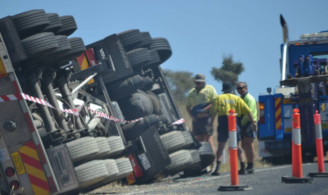 Council staff begin the recovery of the rolled truck between Cowra and Boorowa on the Lachlan Valley Way on Thursday. 