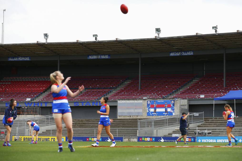 Western Bulldogs' players warm up in front of empty stands prior to the round six AFLW match against and the Fremantle Dockers last month in Melbourne. Those round one matches played in completely empty stadiums were described as hollow and subdued without the fans. Photo: Daniel Pockett/Getty Images