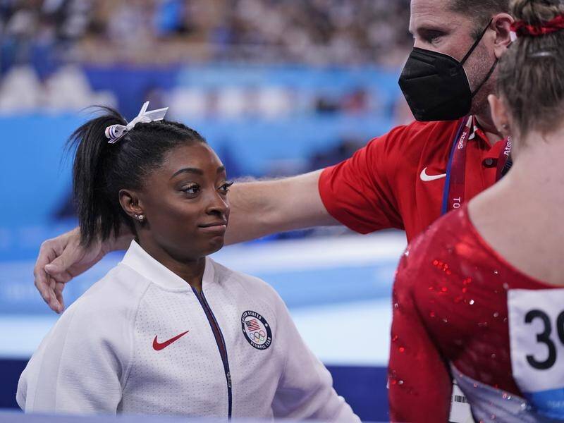 US superstar Simone Biles is comforted after exiting the gymnastics team final following one vault.