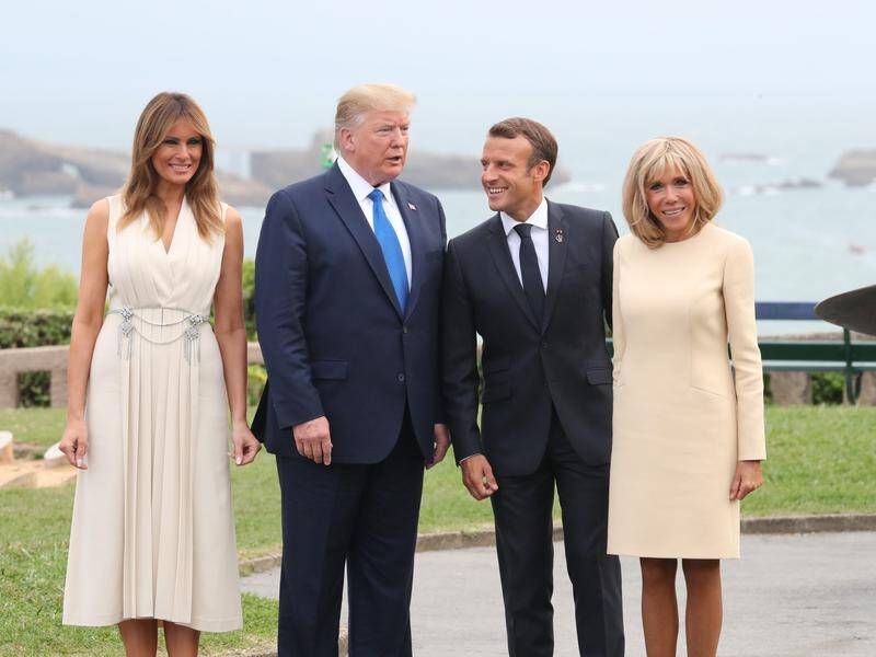 Donald Trump arrived in France after escalating the US trade war with China.